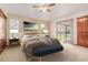 Staged bedroom with vaulted ceiling, a ceiling fan, two windows, and a sliding glass door providing backyard access at 5448 S Swadley Ct, Littleton, CO 80127