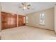 Spacious bedroom with vaulted ceiling, a ceiling fan, two windows, and a large closet with wood doors at 5448 S Swadley Ct, Littleton, CO 80127