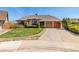 Charming home with a well-manicured lawn, large driveway, and attached two-car garage at 5448 S Swadley Ct, Littleton, CO 80127