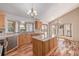 Bright kitchen featuring granite countertops, wood cabinets, a kitchen island, and hardwood floors at 5448 S Swadley Ct, Littleton, CO 80127