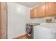Functional laundry room with modern washer and dryer and ample cabinet space at 5448 S Swadley Ct, Littleton, CO 80127