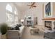 Bright living room features large windows, vaulted ceilings, and a cozy fireplace with staged furniture at 5448 S Swadley Ct, Littleton, CO 80127