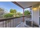View from balcony with black metal railing overlooking a lush green space, blue sky, and an air conditioning unit at 8450 Decatur St # 97, Westminster, CO 80031