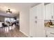 Dining area leading to the living room, featuring modern light fixture and gray wood flooring at 8450 Decatur St # 97, Westminster, CO 80031
