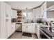 Well-lit kitchen boasting stainless steel appliances, white cabinets, and open wooden shelves at 8450 Decatur St # 97, Westminster, CO 80031