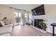 Bright living room with modern fireplace, large TV, and sliding glass doors to a balcony at 8450 Decatur St # 97, Westminster, CO 80031
