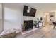 Open living area featuring a decorative fireplace, large TV, and new laminate wood flooring at 8450 Decatur St # 97, Westminster, CO 80031