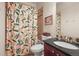 Charming bathroom with patterned shower curtain, classic tile, and stylish fixtures and a framed mirror at 2801 W 23Rd Ave, Denver, CO 80211