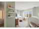 A well-lit bedroom features soft green walls and decor, with three windows providing outside views at 2801 W 23Rd Ave, Denver, CO 80211