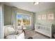 Serene Bedroom with a crib, comfortable armchair, and window letting in natural light, perfect for a calming space at 2801 W 23Rd Ave, Denver, CO 80211