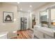Bright kitchen with stainless steel appliances, farmhouse sink, white cabinetry, and access to the outdoors at 2801 W 23Rd Ave, Denver, CO 80211