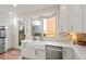 Stylish kitchen featuring white cabinetry, stainless steel appliances, and a farmhouse sink with backyard views at 2801 W 23Rd Ave, Denver, CO 80211