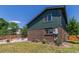 Backyard features green siding, a brick foundation, and flower beds surrounding a patio at 9400 W Burgundy Ave, Littleton, CO 80123