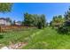 The backyard showcases a creek with a culvert, surrounded by grass and mature trees, offering a serene outdoor space at 9400 W Burgundy Ave, Littleton, CO 80123