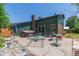 Backyard area with hot tub, patio furniture, green siding, and brick chimney at 9400 W Burgundy Ave, Littleton, CO 80123