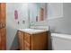 Small bathroom featuring wood vanity, mirror, toilet, and gray walls at 9400 W Burgundy Ave, Littleton, CO 80123