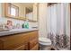 Modest bathroom featuring a wood vanity with a stone countertop and decorative shower curtain at 9400 W Burgundy Ave, Littleton, CO 80123