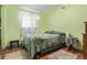 Bedroom featuring green walls, a bed, window, and wood-style flooring at 9400 W Burgundy Ave, Littleton, CO 80123