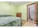 Bedroom featuring green walls, a bed, and doorway leading to the stairwell at 9400 W Burgundy Ave, Littleton, CO 80123