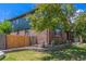 Two-story brick home featuring lush landscaping, a retaining wall, and mature trees at 9400 W Burgundy Ave, Littleton, CO 80123