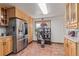 Bright kitchen features stainless steel appliances, wooden cabinets, and tile flooring for a modern touch at 9400 W Burgundy Ave, Littleton, CO 80123