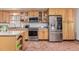 Well-equipped kitchen featuring stainless steel appliances, ample storage, tile flooring, and natural wood cabinets at 9400 W Burgundy Ave, Littleton, CO 80123