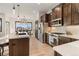 Modern kitchen with stainless steel appliances, white countertops, and dark wood cabinets at 16482 Ledyard S Rd, Platteville, CO 80651