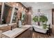 Spa-like bathroom with dual sinks, soaking tub, and unique wood and stone accents at 5408 E Briarwood Cir, Centennial, CO 80122