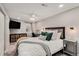 Serene bedroom featuring a tv, desk area, and luxurious bedding with decorative pillows at 5408 E Briarwood Cir, Centennial, CO 80122