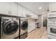 Spacious laundry room boasts modern appliances, ample cabinet space, and a farmhouse sink at 5408 E Briarwood Cir, Centennial, CO 80122
