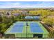 Aerial view of tennis courts surrounded by trees in a neighborhood with mountain views at 2545 Andrew Dr, Superior, CO 80027