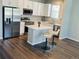 Bright kitchen features white cabinets, an island with seating, and stainless steel appliances at 1353 Reynolds St # 5A, Fort Lupton, CO 80621