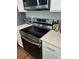 Close up of the stainless steel electric cooktop oven and range, accented by white quartz countertops at 1353 Reynolds St # 5A, Fort Lupton, CO 80621