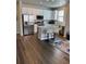 Modern kitchen with stainless steel appliances, white cabinets, a center island, and hardwood floors at 1353 Reynolds St # 5A, Fort Lupton, CO 80621