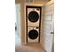 A stacked washer and dryer are inside a laundry closet with white bifold door and carpet flooring at 1353 Reynolds St # 5A, Fort Lupton, CO 80621