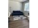 Living room with a comfy blue sofa, modern lighting, and hardwood floor at 1353 Reynolds St # 5A, Fort Lupton, CO 80621
