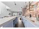 Elegant bar area with light blue cabinetry, brick wall, and open layout at 1449 Wynkoop St # 601, Denver, CO 80202