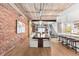 Open-concept dining area with exposed brick wall, wood floors, and view into the kitchen at 1449 Wynkoop St # 601, Denver, CO 80202