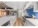 Bright kitchen featuring an island, stainless appliances, blue backsplash, and an adjacent staircase at 1449 Wynkoop St # 601, Denver, CO 80202