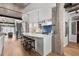 Bright kitchen featuring an island with seating, stainless appliances, blue tile backsplash, and stairs to the second level at 1449 Wynkoop St # 601, Denver, CO 80202
