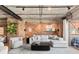 Modern living area with exposed brick wall, wood floors, contemporary furnishings, and a balcony at 1449 Wynkoop St # 601, Denver, CO 80202
