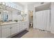 Bright bathroom featuring dual sinks, and vanity mirror, complemented by a shower with a curtain at 6850 Xavier Cir # 5, Westminster, CO 80030