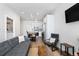 Open living room with grey sofa and chairs, wood coffee table, and kitchen island at 1208 Quitman St # 303, Denver, CO 80204