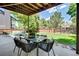 Comfortable patio with dining table & chairs overlooks the spacious backyard and green trees in this landscaped outdoor living space at 10016 Teton Ct, Lone Tree, CO 80124