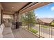 Covered balcony with comfortable seating, featuring views of the neighborhood and beyond at 4364 Chateau Ridge Ln, Castle Rock, CO 80108