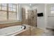 Bright bathroom with separate tub and glass shower and large windows at 4364 Chateau Ridge Ln, Castle Rock, CO 80108