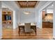 Elegant dining room with hardwood floors, designer lighting, and a coffered wood ceiling at 4364 Chateau Ridge Ln, Castle Rock, CO 80108