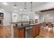 Kitchen island with dark countertops and wood cabinets, opens to the dining area and living area at 4364 Chateau Ridge Ln, Castle Rock, CO 80108