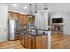 Open kitchen features stainless appliances, granite countertops, wood cabinets, and view of the fireplace and living room at 4364 Chateau Ridge Ln, Castle Rock, CO 80108