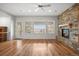 Open living room features a ceiling fan, a stone fireplace, a glass door and view of the surrounding area at 4364 Chateau Ridge Ln, Castle Rock, CO 80108